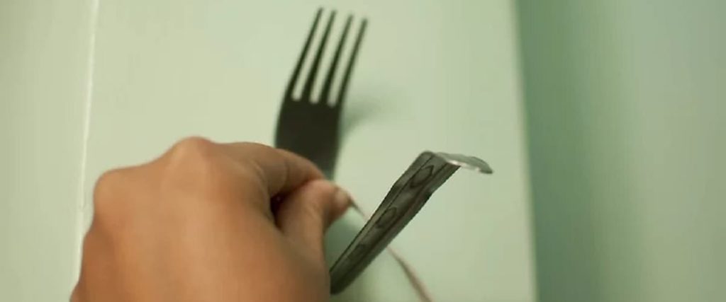 main tenant une fourchette tordue